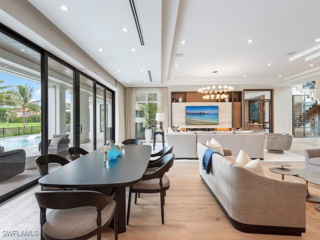 dining area with recessed lighting, light wood-style flooring, and an inviting chandelier