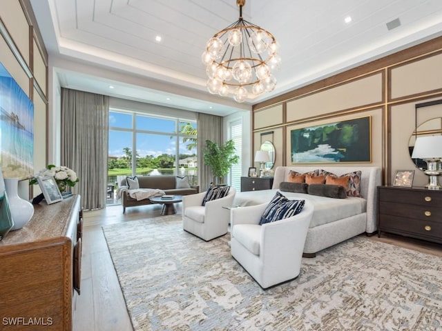 interior space featuring a chandelier, recessed lighting, wood finished floors, visible vents, and a raised ceiling
