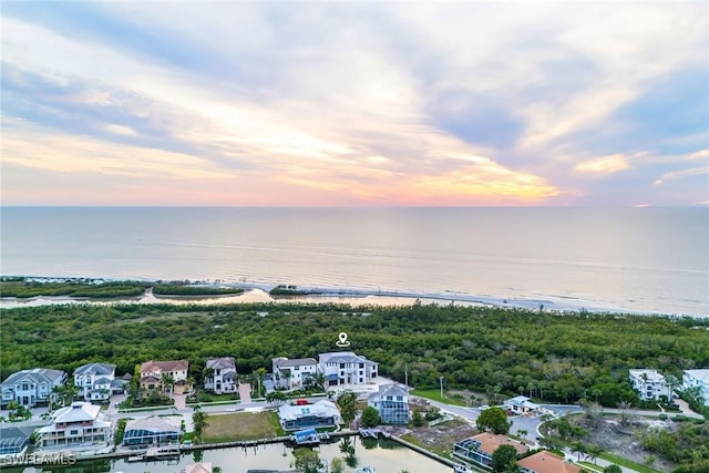 aerial view at dusk featuring a water view