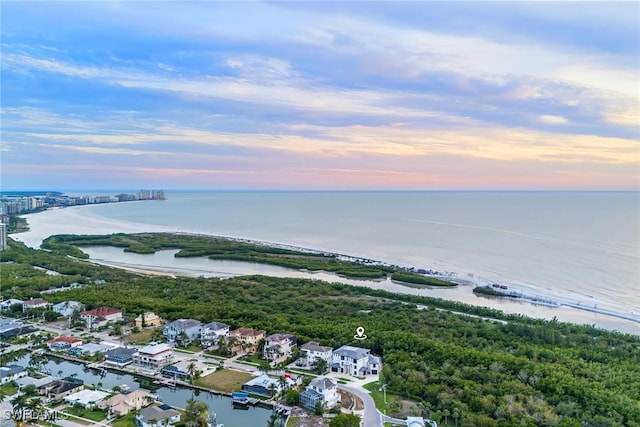 aerial view at dusk featuring a water view