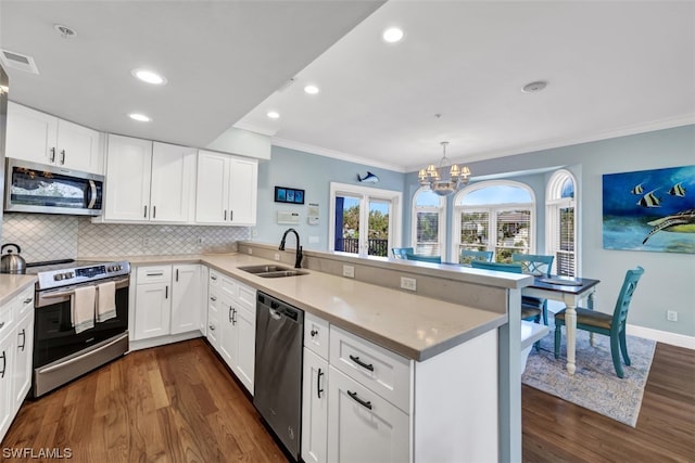 kitchen with dark hardwood / wood-style floors, kitchen peninsula, sink, hanging light fixtures, and appliances with stainless steel finishes