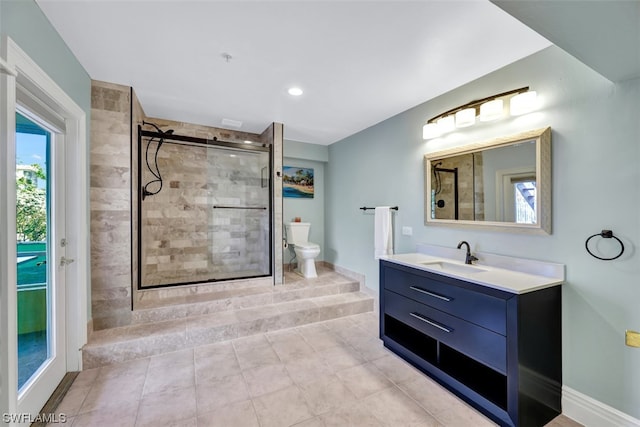 bathroom with a shower with door, vanity with extensive cabinet space, tile floors, and toilet