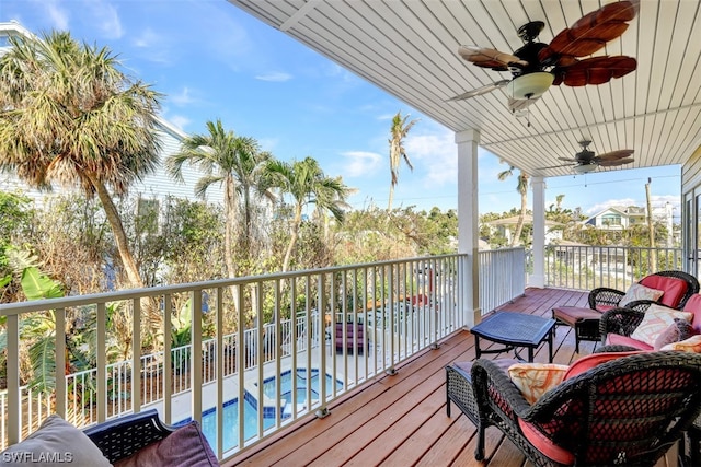 balcony featuring a fenced in pool and ceiling fan