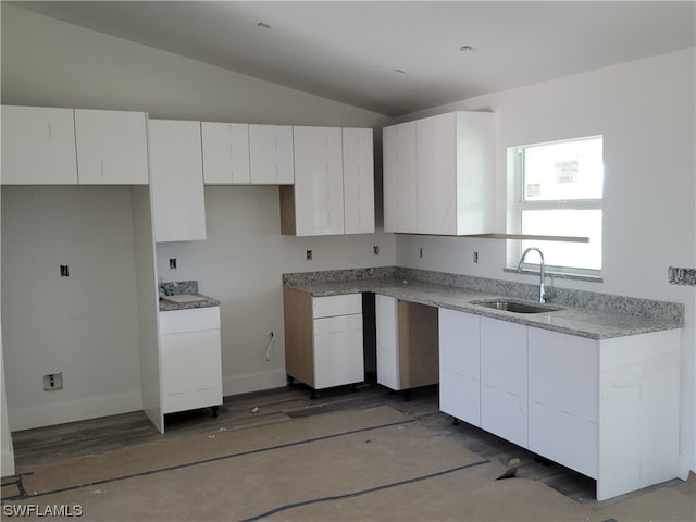 kitchen featuring lofted ceiling, dark wood-type flooring, sink, and white cabinetry