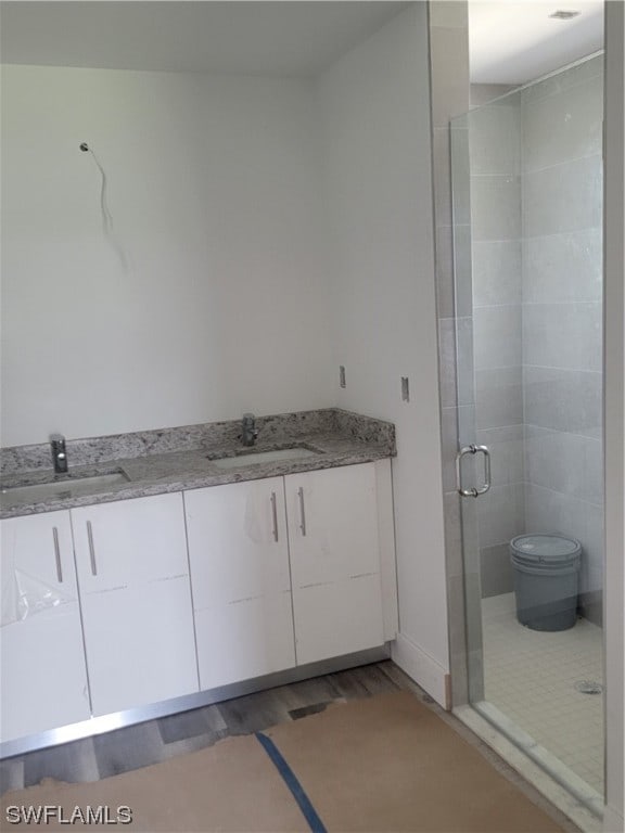 bathroom featuring an enclosed shower, hardwood / wood-style floors, toilet, and sink