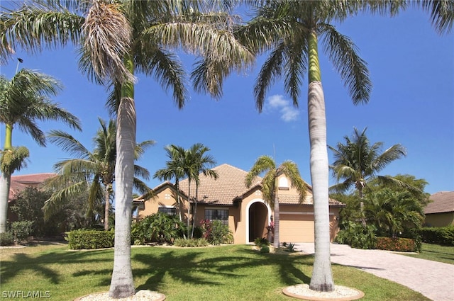 mediterranean / spanish-style house featuring a front lawn and a garage