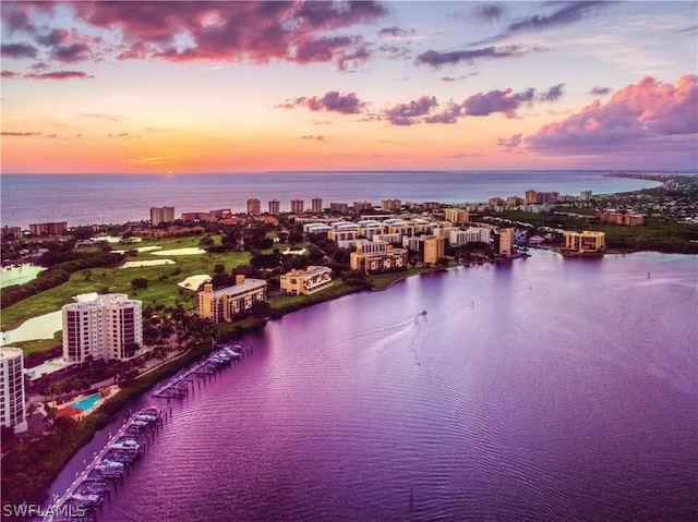 aerial view at dusk with a view of city and a water view