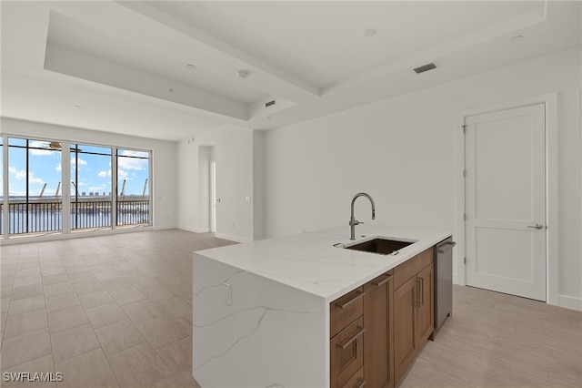 kitchen with a water view, a sink, visible vents, open floor plan, and brown cabinetry