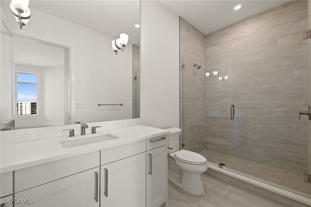 bathroom featuring a stall shower, vanity, and toilet