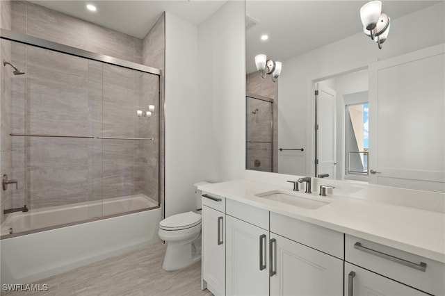 full bath featuring toilet, bath / shower combo with glass door, wood finished floors, and vanity