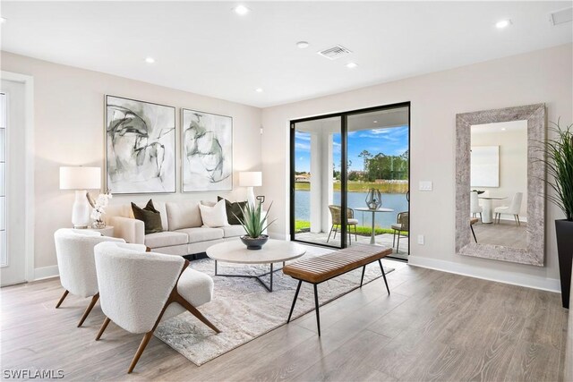 living room with hardwood / wood-style flooring and a water view