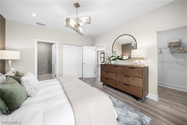 bedroom with hardwood / wood-style flooring and ensuite bathroom