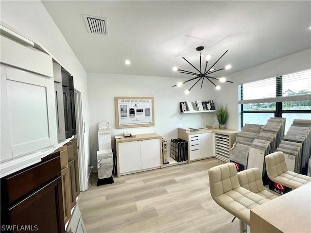 living room with light wood-type flooring and a chandelier