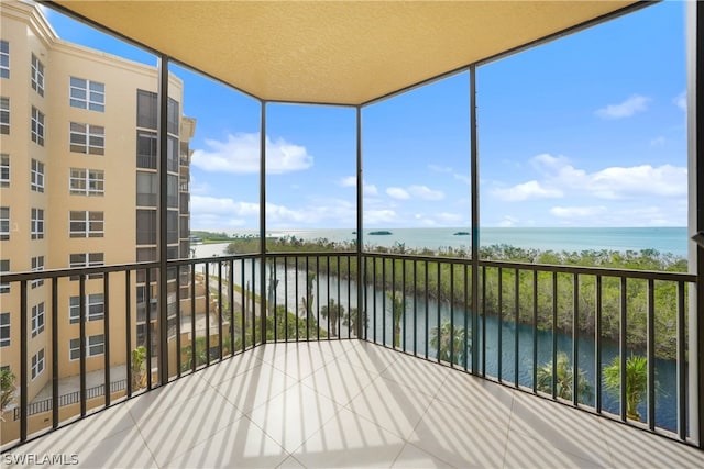 unfurnished sunroom featuring a water view