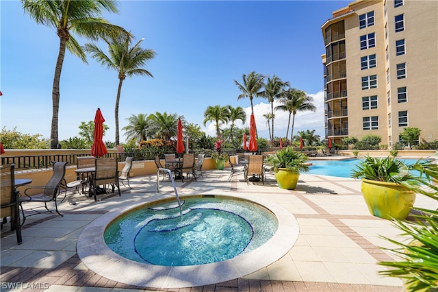 view of pool featuring a community hot tub and a patio