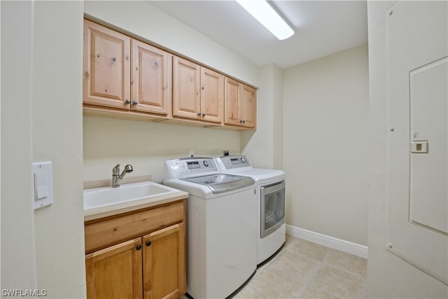 washroom with cabinets, washer and clothes dryer, sink, and light tile patterned flooring