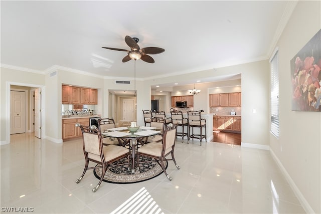 tiled dining area with ceiling fan with notable chandelier, sink, and ornamental molding