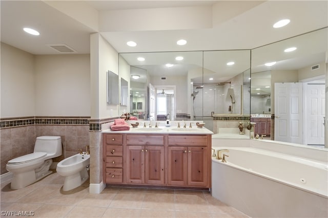 full bathroom featuring toilet, shower with separate bathtub, tile walls, a bidet, and vanity