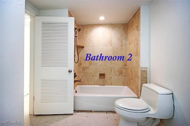 bathroom with toilet, tile patterned flooring, and tiled shower / bath