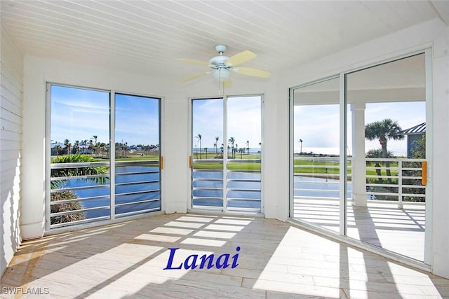 sunroom / solarium featuring a water view, ceiling fan, and a healthy amount of sunlight