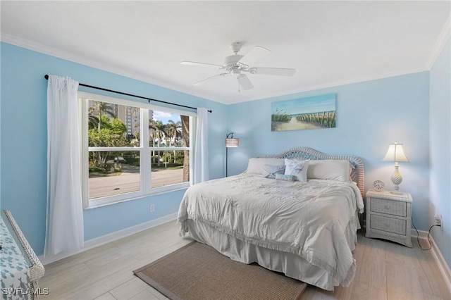 bedroom with light hardwood / wood-style flooring, ceiling fan, and crown molding