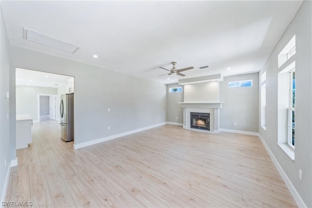 unfurnished living room featuring ceiling fan and light hardwood / wood-style flooring