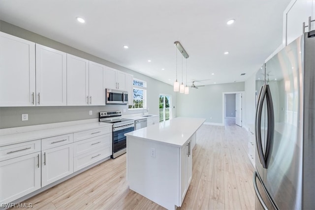 kitchen with white cabinets, decorative light fixtures, and appliances with stainless steel finishes