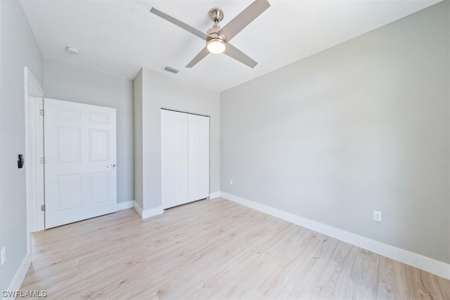 unfurnished bedroom featuring a closet, light hardwood / wood-style floors, and ceiling fan