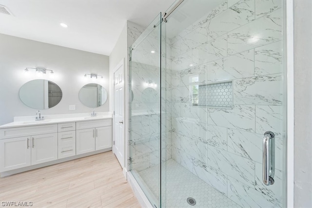 bathroom with vanity, an enclosed shower, and hardwood / wood-style flooring