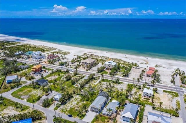 drone / aerial view featuring a beach view and a water view