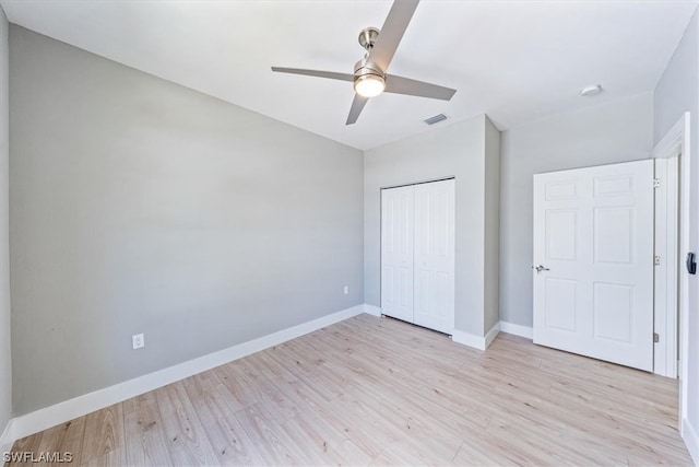 unfurnished bedroom with light hardwood / wood-style flooring, ceiling fan, and a closet