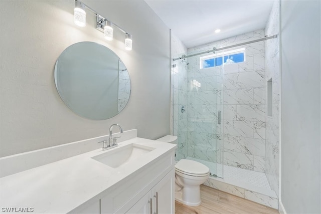 bathroom featuring hardwood / wood-style floors, walk in shower, vanity, and toilet