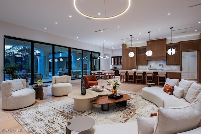 living area with a chandelier, visible vents, recessed lighting, and light wood-style floors