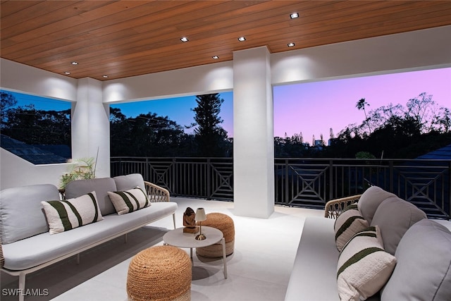 patio terrace at dusk with an outdoor hangout area and a balcony