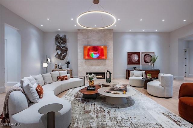 living room featuring recessed lighting, baseboards, wood finished floors, and a tile fireplace