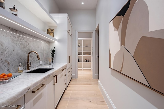 bar with baseboards, recessed lighting, a sink, light wood-style floors, and tasteful backsplash