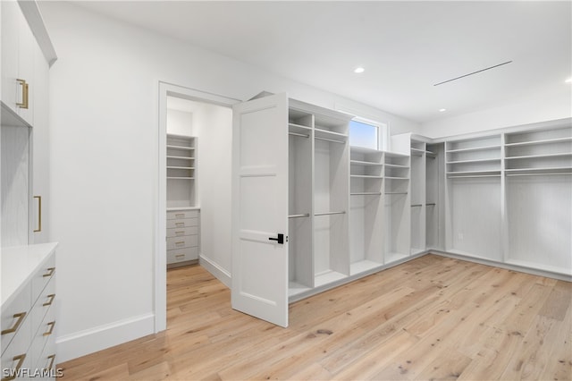 walk in closet with light hardwood / wood-style flooring