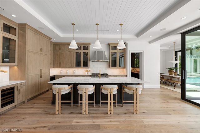 kitchen with wooden ceiling, a kitchen breakfast bar, hanging light fixtures, a large island, and light hardwood / wood-style floors