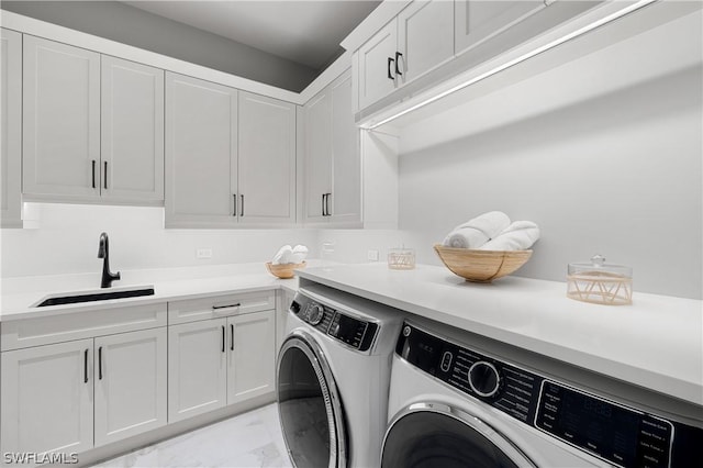 laundry room with washer and dryer, cabinets, and sink