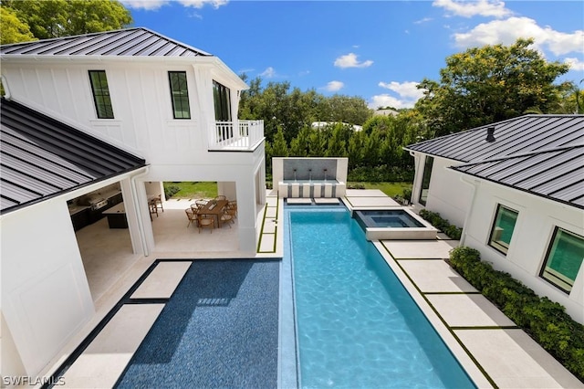 view of pool featuring an in ground hot tub and a patio