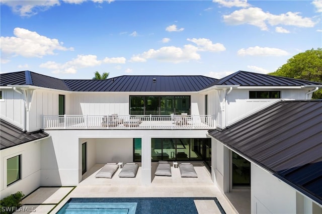 rear view of house with a balcony, a patio, and an outdoor hangout area