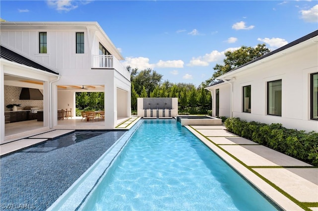 view of pool with a patio, an outdoor kitchen, and ceiling fan