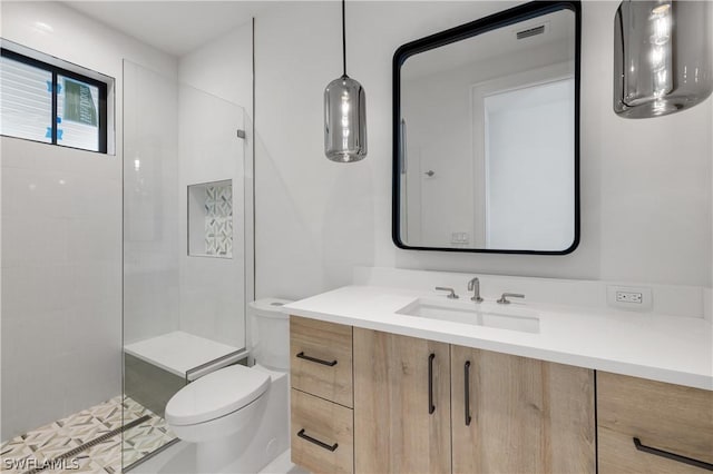 bathroom featuring vanity, toilet, and walk in shower