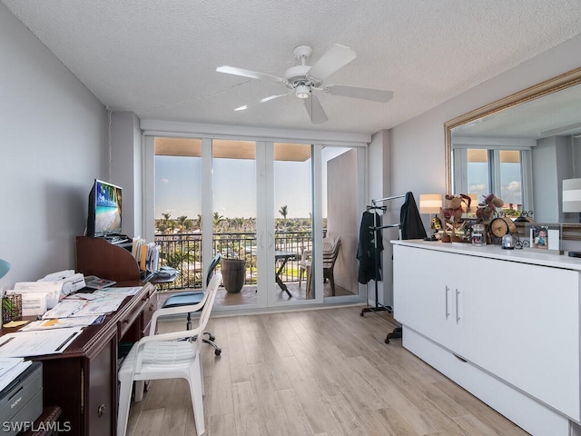 office featuring a textured ceiling, ceiling fan, light wood-type flooring, and french doors