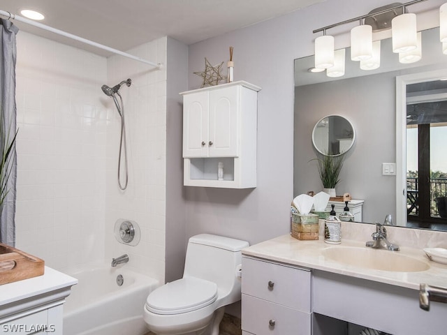 full bathroom featuring tiled shower / bath, toilet, and vanity