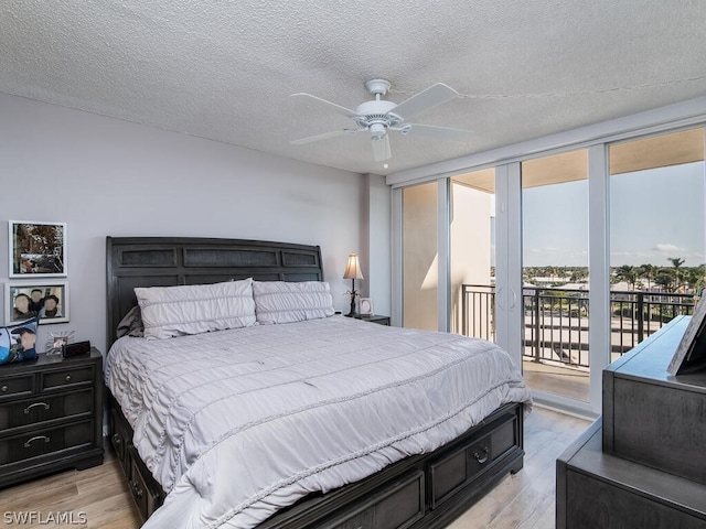 bedroom featuring access to exterior, ceiling fan, floor to ceiling windows, light hardwood / wood-style flooring, and a textured ceiling