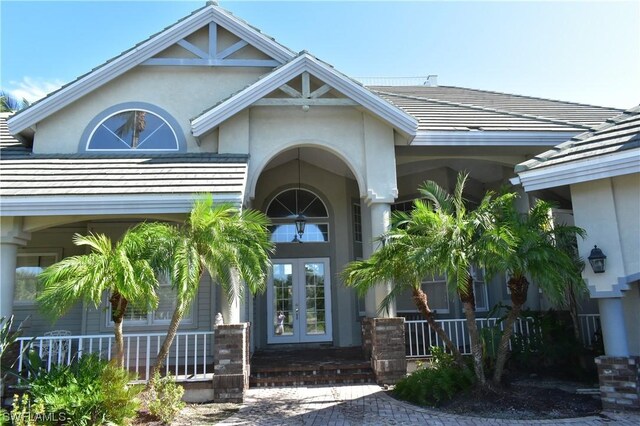 entrance to property featuring covered porch and french doors