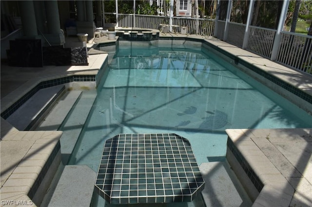 view of swimming pool with an in ground hot tub