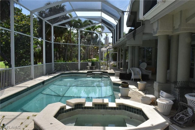 view of swimming pool featuring an in ground hot tub, glass enclosure, and a patio