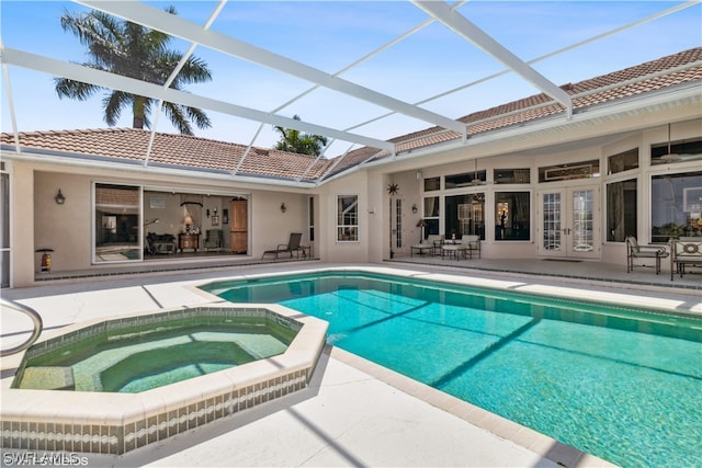 view of pool featuring an in ground hot tub, glass enclosure, and a patio